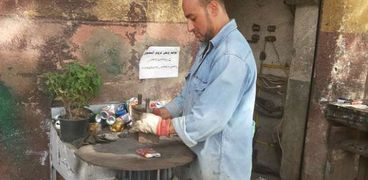 أحمد فى ورشته لإعادة تدوير «الكانز»