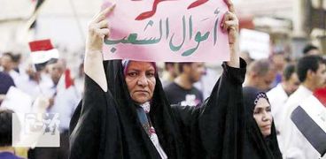 سيدة عراقية ترفع لافتة تندد بالفساد داخل الحكومة العراقية