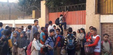 طلاب يتسلقون سور المدرسة لحضور الطابور