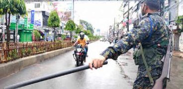 أحد عناصر الجيش في بنجلاديش يطبق حظر التجوال