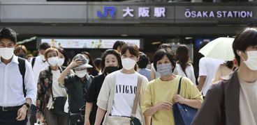 يابانيون يرتدون الكمامات في محطة قطار