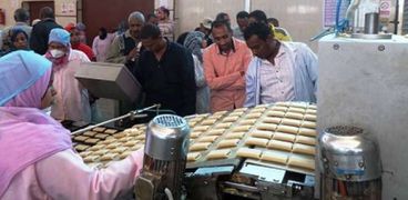 عمال مصنع أسوان أثناء إنتاج آلاف «الفطائر» قبل توقفه عن العمل