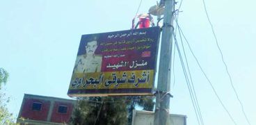 لافتة باسم وصورة الشهيد أمام منزله