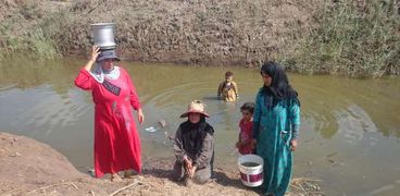 نساء قرية «أولاد على» يجلبن المياه من الترعة