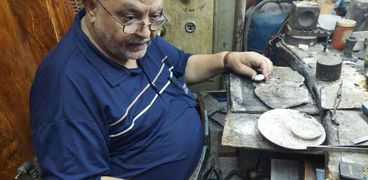 أحمد يجلس في ورشة صناعة الذهب والفضة
