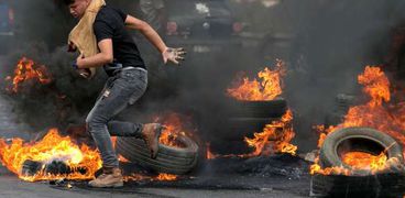 شاب فلسطينى خلال الاشتباكات مع قوات الاحتلال الإسرائيلى أمس «أ.ف.ب»