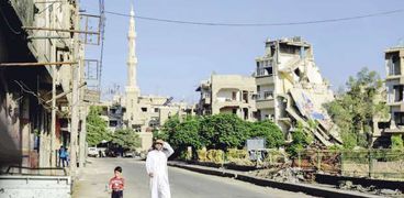 سورى مع ابنه فى بلدة يسيطر عليها المتمردون شرق دمشق 