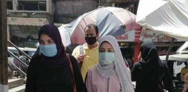 مواطنون يتعايشون مع فيروس كورونا بارتداء الكمامة في الشوارع