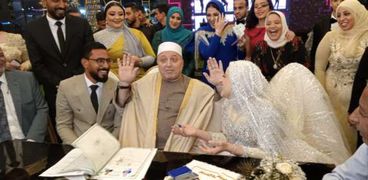 المأذون خالد خليفة يتوسط العروسين