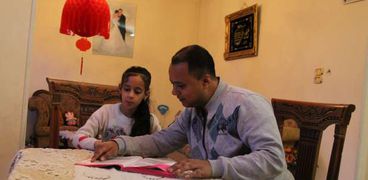 أيمن محمد أثناء المذاكرة لابنته
