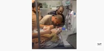 محمد الحديدي يحضتن طفله الرضيع
