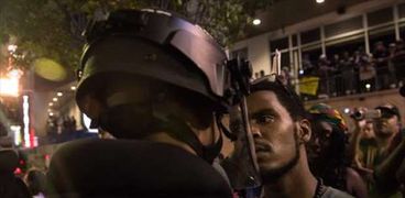 متظاهر يواجه رجل شرطة