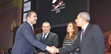 وزير الصناعة والتجارة يصافح عمر عامر أثناء التكريم