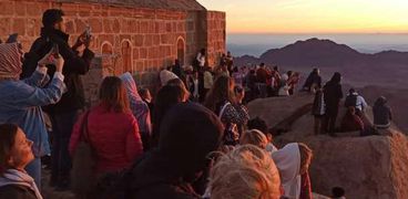 أرشيفية سياح يتقطون صور شروق الشمس فوق جبل موسي