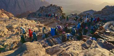 سياح فوق قمة جبل موسي يشاهدون شروق الشمس