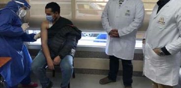 أحد أفراد الفرق الطبية خلال أخذ جرعة تطعيم ضد «كورونا»