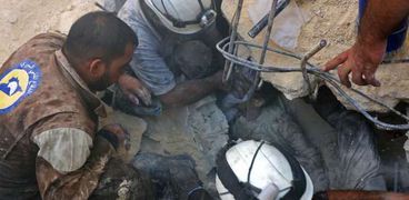 الدفاع المدنى يحاول إخراج أحد ضحايا القصف على حلب من تحت الأنقاض «أ.ف.ب»