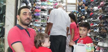 أب يحاول شراء ملابس العيد لأطفاله بأسعار مقبولة