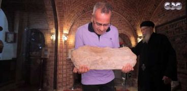 الإعلامي جابر القرموطي يحمل الحجر المطبوع عليه قدم المسيح عليه السلام
