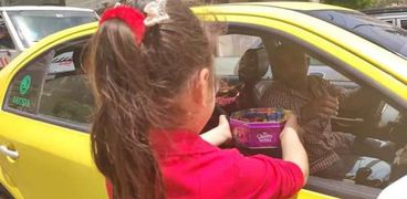 طفلة من مصابي التوحد توزع حلوى العيد على سائق