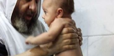 تعميد طفل في عيد الغطاس بالمنيا