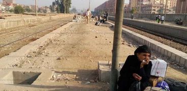 مسنة تجلس على حجر منتظرة قطار على محطة ابو تيج
