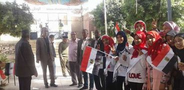 بالصور| طلاب إدارة دشنا التعليمية يستقبلون الناخبين بالأعلام والورود