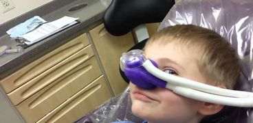 طفل أثناء استنشاق الغاز الضاحك في عيادة الأسنان