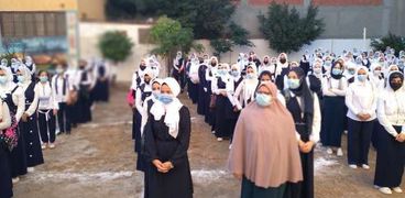 الطالبات يلتزمن بارتداء الكمامات الطبية أثناء طابور الصباح لمواجهة كورونا