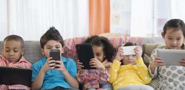 أطفال ينظرون إلى شاشات الأجهزة اللوحية