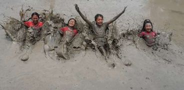 أطفال يلعبون في الطين- أرشيفية