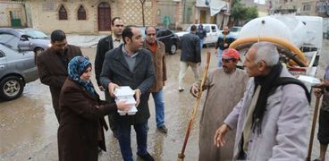 محمد موسى نائب محافظ المنوفية خلال توزيع وجبات غذائية على العاملين فى شفط المياه من الشوارع