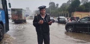 ضابط شرطة يقف وسط الأمطار