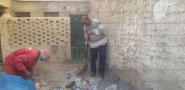 نائب رئيس حي بالغردقة يحمل المقشة ويساعد عامل فى نظافة شوارع المدينة