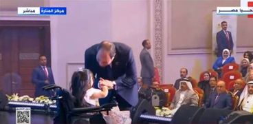 الرئيس السيسي يقبّل يد طفلة من ذوي الهمم
