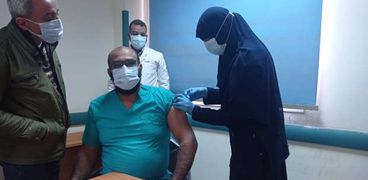أحد الأطقم الطبية أثناء تلقية جرعة لقاح كورونا