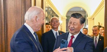 الرئيس الصيني يشاهد صورته على هاتف بايدن