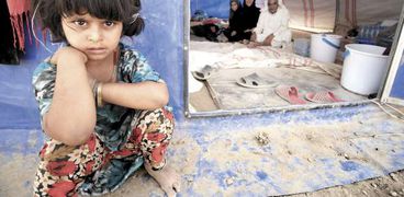 طفلة مع أسرتها داخل أحد مخيمات الفارين من الفلوجة بالعراق «أ.ف.ب»