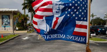 أحد مناصري ترمب يرفع علما عليه صورة الرئيس في فلوريدا