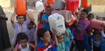 الأطفال يحملون الجراكن لملئ مياه من شركة البترول