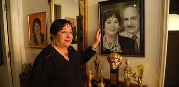 الفنانة سميرة عبدالعزيز في منزلها أمام صورة تجمعها وزوجها محفوظ عبدالرحمن