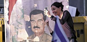 إسرائيلية تلتقط «سيلفى» مع صورة «صدام»