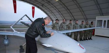 أردوغان مرتديا بزة طيار ويوقع على الطائرة