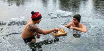 رجلان يلعبان الشطرنج في بحيرة جليدية