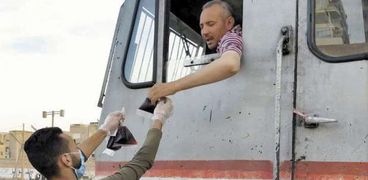 متطوع يقدم العصير لسائق القطار