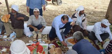 "فطير وعسل" . رئيس جامعة سوهاج يشارك عمال المزرعة غدائهم بعد "دريس القمح"