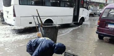 عمال النظافة في شوارع الإسكندرية لكسح المياه وتنظيفها