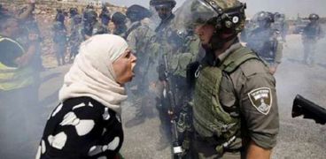 سيدة فلسطينية تقف أمام جنود الاحتلال