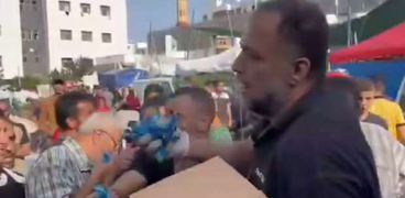 فلسطيني يوزع حلوى بعد استشهاد زوجته وأطفاله