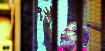 مرسى يلوح إلى محاميه أثناء محاكمته «صورة أرشيفية»
